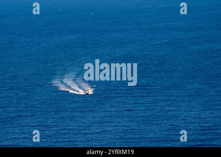 Ein kleines Vergnügen-Motorboot segelt mit hoher Geschwindigkeit auf einem ruhigen blauen Meer Stockfoto