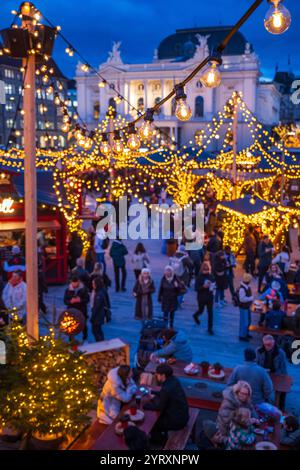 3-12-2024 Zürich, Schweiz. Besucher besuchen Pop-up-Shops auf dem Weihnachtsmarkt am Sechselautenplatz. Blaue Stunde am späten Abend, Weihnachtsbeleuchtung. Stockfoto