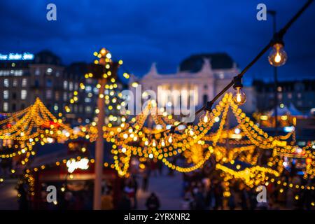 3-12-2024 Zürich, Schweiz. Besucher besuchen Pop-up-Shops auf dem Weihnachtsmarkt am Sechselautenplatz. Blaue Stunde am späten Abend, Weihnachtsbeleuchtung. Stockfoto