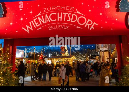 3-12-2024 Zürich, Schweiz. Besucher besuchen Pop-up-Shops auf dem Weihnachtsmarkt am Sechselautenplatz. Blaue Stunde am späten Abend, Weihnachtsbeleuchtung. Stockfoto