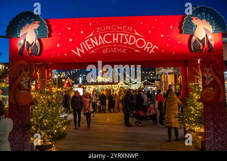 3-12-2024 Zürich, Schweiz. Besucher besuchen Pop-up-Shops auf dem Weihnachtsmarkt am Sechselautenplatz. Blaue Stunde am späten Abend, Weihnachtsbeleuchtung. Stockfoto