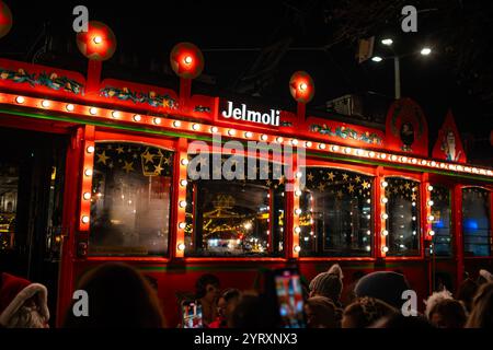 3-12-2024 Zürich, Schweiz. Am späten Abend versammelten sich Leute, um an Bord der berühmten Weihnachtsmotive dekorierten Jelmoli-Straßenbahn zu gehen. Stockfoto