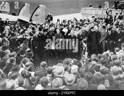 Neville Chamberlain hält das Papier, das die Resolution enthält, sich zu friedlichen Methoden zu verpflichten, die von Hitler und ihm bei seiner Rückkehr aus München unterzeichnet wurden. Flugplatz Heston am 30. September 1938. Stockfoto