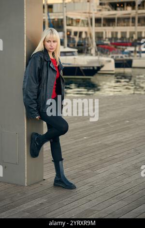 Modemodel posiert am Hafen, trägt Lederjacke und Stiefel Stockfoto