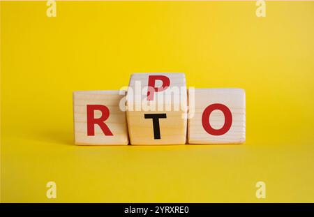 RPO vs. RTO-Symbol. Holzwürfel mit den Worten RTO bis RPO. Schöner gelber Hintergrund. Geschäftskonzept. Kopierbereich Stockfoto