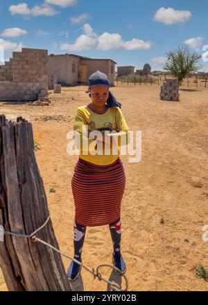 afrikanische Frau aus dem Dorf steht im Hof mit überkreuzten Armen Stockfoto