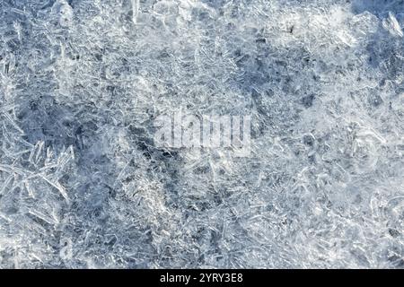 Eiskristalle, die im Sonnenlicht schmelzen, natürliche Hintergrundstruktur, Makrofoto mit selektivem Fokus Stockfoto