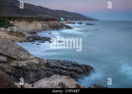Die Wellen krachen sanft gegen die zerklüfteten Klippen des Leo Carrillo State Beach und zeigen die ruhige Schönheit von Malibu in der Dämmerung. Stockfoto