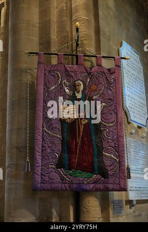 Romsey, Southampton, England. November 2024. Im Inneren der Romsey Abbey: Eine gestickte Platte, die St. Ethelfleda zeigt. Stockfoto