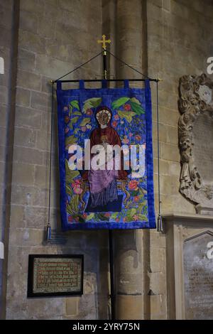 Romsey, Southampton, England. November 2024. Innerhalb der Romsey Abbey: Eine Dame und ein Kind, ein Wandteppich innerhalb der Abtei. Stockfoto