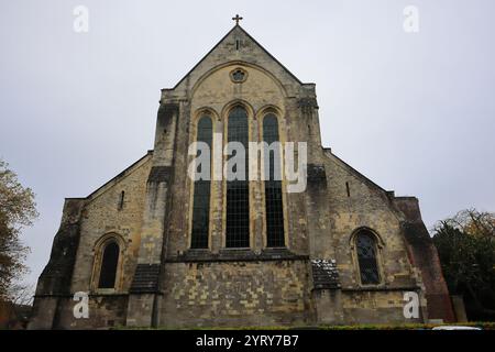 Romsey, Southampton, England. November 2024. Romsey Abbey: Blick auf das Äußere mit zwei kleinen Buntglasfenstern und einem Triptychon im mittleren Bereich. Stockfoto