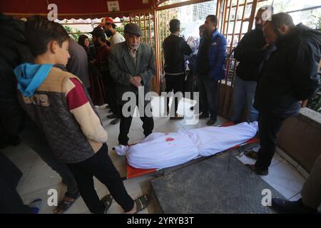 Menschen beten neben den Leichen von Palästinensern, die nach israelischen Streiks getötet wurden, im al-Aqsa Krankenhaus in Deir al Balah Menschen beten neben den Leichen von Palästinensern, die nach israelischen Streiks getötet wurden, im al-Aqsa Krankenhaus in Deir al Balah, Zentral-Gazastreifen, 05. Dezember 2024. Nach Angaben des palästinensischen Gesundheitsministeriums in Gaza wurden mindestens 25 Palästinenser nach israelischen Luftangriffen im südlichen und mittleren Gazastreifen getötet. Nach Angaben des palästinensischen Gesundheitsministeriums und der israelischen Armee sind seit dem israelischen Krieg im Gazastreifen mehr als 45.000 Palästinenser und über 1.400 Israelis getötet worden Stockfoto