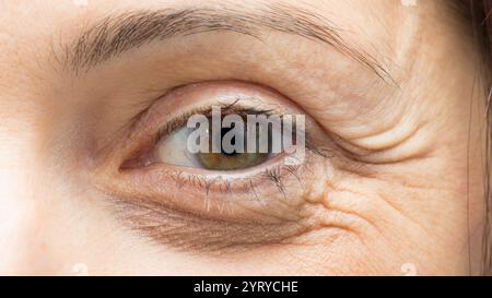 Nahaufnahme der alternden Haut, die Falten um das Auge einer Frau zeigt und die Auswirkungen der Zeit und des Alterns hervorhebt Stockfoto