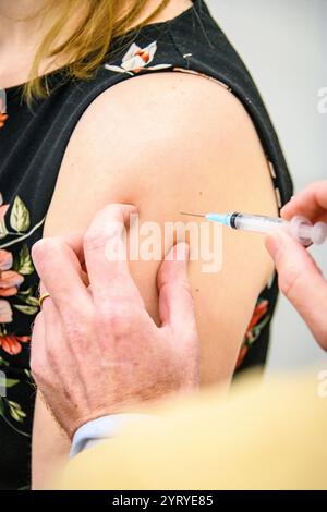 Nahaufnahme eines medizinischen Fachpersonals, das eine Impfung in den Arm eines Patienten verabreicht, wobei der Schwerpunkt auf Immunisierung und öffentliche Gesundheit gelegt wird. Stockfoto