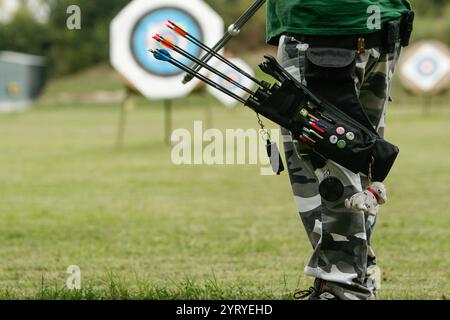 Archer hält einen Köcher voller Pfeile an einem Bogenschießstand, der sich auf die Zielübungen vorbereitet Stockfoto