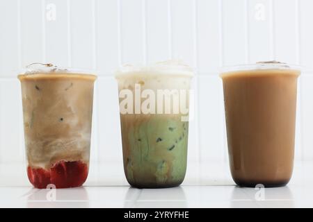 Drei verschiedene Iced Drink Coffee, Erdbeere Espresso Latte, Grüner Tee Matcha Milk Latte und Kopi Susu Gula Aren Stockfoto