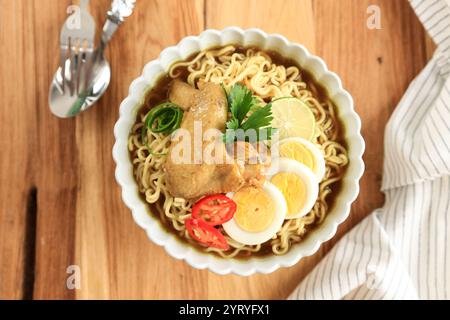 Indomie Soto Ayam, Chicken Nudelsuppe von oben auf Holztisch Stockfoto