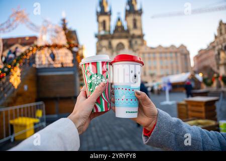 Prag, Tschechische republik - 4. Dezember 2024: Nahaufnahme von zwei jungen Frauen, die auf der Straße von Prag im großen Starbucks-Weihnachtskaffee halten Stockfoto