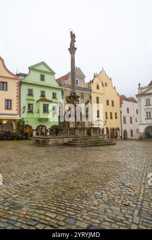 Ein stimmungsvoller Herbstblick auf den Platz in Cesky Krumlov, mit der barocken Pestsäule mit der Statue der Jungfrau Maria Immaculata, umgeben von Nebel, Stockfoto