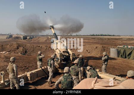 Das US Marine Corps (USMC) M-198 155mm Haubitzer Gun Crew des 4. Bataillons, 14. Marines, Mike Battery, Gun 4, von links nach rechts, Gunnery Sergeant (GYSGT) Justin Grafton, Cannoneer Private First Class (PFC) Matthew Camp, Section Chief Sergeant (SGT) Mike Dasher, Cannoneer Lance Corporal (LCPL) Josh Rosenberger, Cannoneer Corporal (CPL) will McGee, Munition Team Chief CPL Jonathan Laie und Kanonier LCPL Jonathan Fox. Marines in Camp Falludschah, Irak (IRQ), greifen feindliche Ziele an, um die Operation IRAQI FREEDOM zu unterstützen. Stockfoto