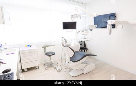 Leere Zahnklinik mit moderner Ausstattung, einschließlich eines Zahnarztstuhls, Monitors und anderer Werkzeuge, die für Patienten bereit sind Stockfoto