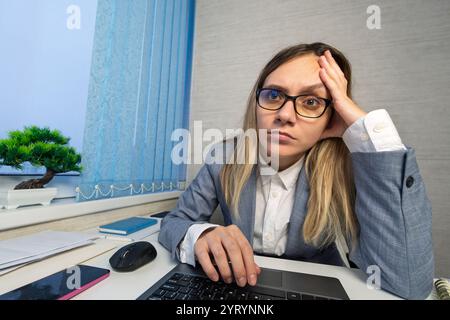 Kopfschmerzen, Laptop und Frau im Büro, erschöpft mit 404 Fehler, Stress oder Web-Problem. Frustriert, müde und müde Mädchen mit Burnout, Angst A Stockfoto