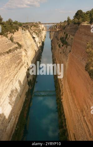 Der Kanal von Korinth in Griechenland verbindet den Golf von Korinth im Ionischen Meer mit dem Saronischen Golf in der Ägäis. Sie durchschneidet den engen Isthmus von Korinth und trennt den Peloponnes vom griechischen Festland, wodurch die Halbinsel zu einer Insel wird. Der Kanal ist 6,4 Kilometer lang und nur 24,6 Meter (80,7 Fuß) breit auf Meereshöhe. Der Kanal wurde ursprünglich in klassischer Zeit vorgeschlagen und im 1. Jahrhundert n. Chr. wurde ein gescheiterter Versuch unternommen, ihn zu bauen. Der Bau wurde 1881 wieder aufgenommen, wurde aber durch geologische und finanzielle Probleme behindert, die die ursprünglichen Bauherren in Konkurs brachten. Es war Co Stockfoto