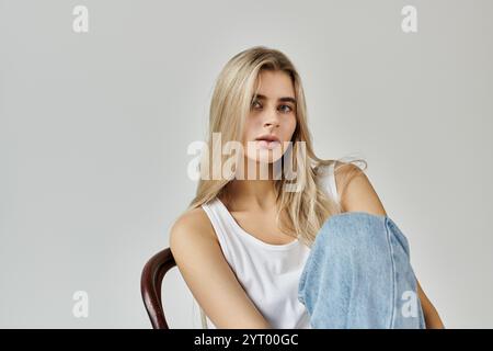 Eine atemberaubende junge Frau mit langen blonden Haaren posiert in einem modernen Studio. Stockfoto