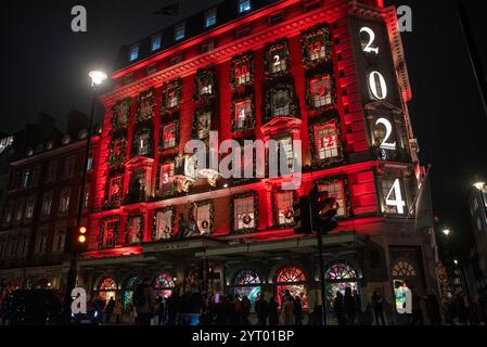 London, Großbritannien. Dezember 2024. Die Leute gehen vor das Fortnum & Mason Gebäude, das wie ein Adventskalender auf dem Piccadilly in London dekoriert ist. Die britische Hauptstadt London ist auf der ganzen Welt sehr berühmt für ihre Weihnachtsbeleuchtung, Märkte und ikonischen Gebäude. Viele Gebäude sind sehr elegant dekoriert. (Foto: Krisztian Elek/SOPA Images/SIPA USA) Credit: SIPA USA/Alamy Live News Stockfoto