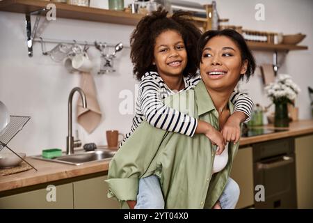 Eine Mutter teilt einen schönen Moment mit ihrer Tochter und genießt spielerische Zuneigung in der Küche. Stockfoto