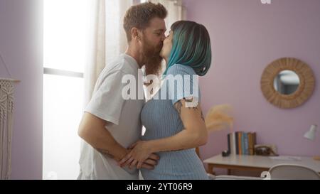 Schwangere Frau küsst Mann im gemütlichen Wohnzimmer, zeigt Liebe und Zweisamkeit Stockfoto