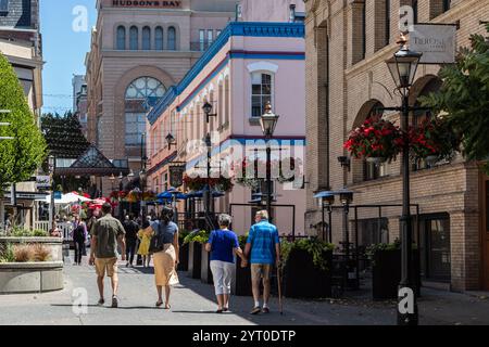 Blick auf die Stadt mit historischer Architektur in der Innenstadt von Victoria. Leute laufen in einem Einkaufsviertel von Victoria BC, Kanada. Straßenansicht, Reisefoto, bearbeiten Stockfoto