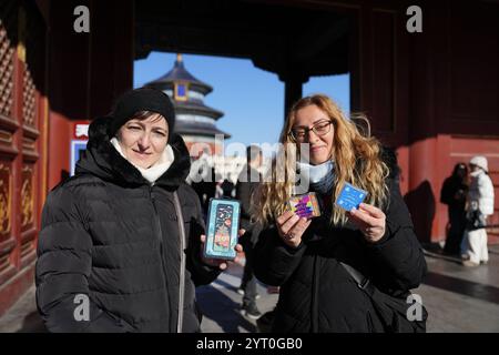 (241205) -- PEKING, 5. Dezember 2024 (Xinhua) -- Touristen aus Ungarn zeigen Souvenirs, die im Tiantan (Tempel des Himmels) Park in Peking, Hauptstadt Chinas, gekauft wurden, 5. Dezember 2024. Die Ausweitung der visafreien Politik ist ein Meilenstein auf Chinas Weg zu größerer Offenheit und zeigt auch sein Vertrauen auf der globalen Bühne. Bisher genießen 38 Länder einseitigen visafreien Zugang, und der maximale Aufenthalt für Besucher wurde ab November 30 auf 30 Tage verlängert. Im dritten Quartal 2024 erreichte die Zahl der Ausländer, die nach China einreisten, 8,186 Millionen, was einem Anstieg von 48,8 Prozent gegenüber dem Vorjahr entspricht. Darunter 4,885 Millionen Entrecht Stockfoto