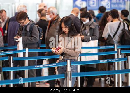 (241205) -- PEKING, 5. Dezember 2024 (Xinhua) -- Ein Tourist aus Japan (vorne) wartet auf die Einreisekontrolle am Beijing Capital International Airport in Peking, Hauptstadt Chinas, 4. Dezember 2024. Die Ausweitung der visafreien Politik ist ein Meilenstein auf Chinas Weg zu größerer Offenheit und zeigt auch sein Vertrauen auf der globalen Bühne. Bisher genießen 38 Länder einseitigen visafreien Zugang, und der maximale Aufenthalt für Besucher wurde ab November 30 auf 30 Tage verlängert. Im dritten Quartal 2024 erreichte die Zahl der Ausländer, die nach China einreisten, 8,186 Millionen, was einem Anstieg von 48,8 Prozent gegenüber dem Vorjahr entspricht. Unter ihnen 4. Stockfoto