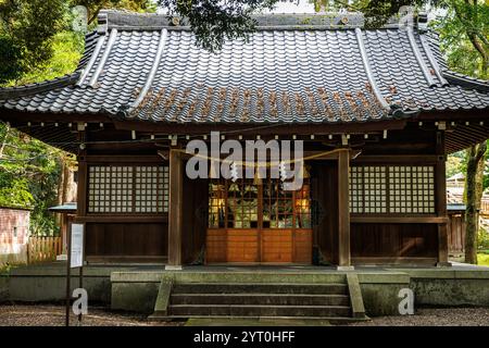 Ein wunderschöner und ruhiger Blick auf einen traditionellen japanischen Schrein, perfekt eingebettet in das üppige, lebhafte Grün Stockfoto
