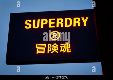 Köln, 4. Dezember 2024: Beleuchtetes SUPERDRY-Werbeschild am Eingang des Ladengeschäfts in der schildergasse in köln Stockfoto