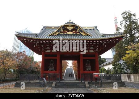 Ehemaliges Taitoku-in Mausoleum Tor, Shiba Park, Minato-Ku, Tokio, Japan. Im Hintergrund der Tokio Tower, offiziell Japan Radio Tower. Stockfoto