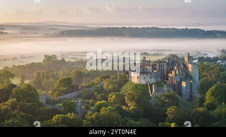 Aus der Vogelperspektive auf Arundel Castle bei Sonnenaufgang an einem nebeligen Sommermorgen, Arundel, Sussex, England. Sommer (Juli) 2024. Stockfoto