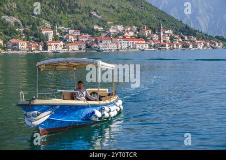 Blick auf die Stadt Perast vom Meer aus mit einem Boot im Vordergrund: Eine UNESCO-Weltkulturerbe-Stadt in der Bucht von Kotor, Montenegro, Europa. Stockfoto