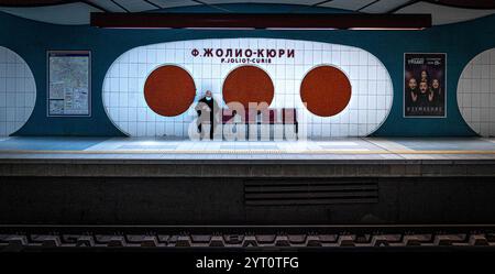 Die moderne U-Bahn-Station „P. Joliot-Curie“ von Sofia bietet einzigartige runde Wandmotive, leuchtende Farben und einen einsamen Pendler auf dem Bahnsteig. Stockfoto