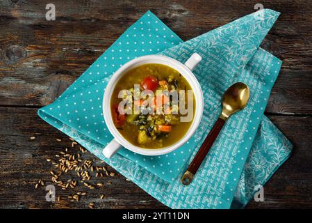 Gemüsesuppe mit Schreibschrift in einer weißen Keramikschale auf einem rustikalen Tisch Stockfoto