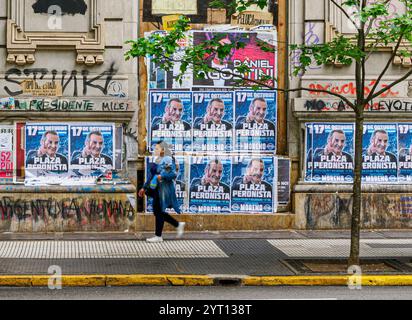 Buenos Aires Straßenszene mit einer Frau, die am 17. Oktober in Argentinien an einem Gebäude vorbeifährt, das mit Plakaten für den Loyalty Day beworben wurde Stockfoto