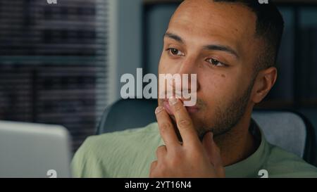 afroamerikanischer Managerin, der auf Laptop-Bildschirm schaut, Finanzberichte schreibt, Daten aus dem Internet analysiert junge ethnische Geschäftsleute schreiben Notizen, die tun Stockfoto