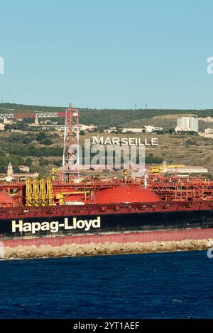 Marseille, Frankreich - 4. Dezember 2024: Hafen von Marseille mit einer Fähre von Corsica Linea, umgeben von städtischen Gebäuden und majestätischen Bergen, Stockfoto