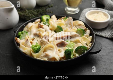 Köstliche Pasta Alfredo mit Huhn serviert auf schwarzem Tisch, Nahaufnahme Stockfoto