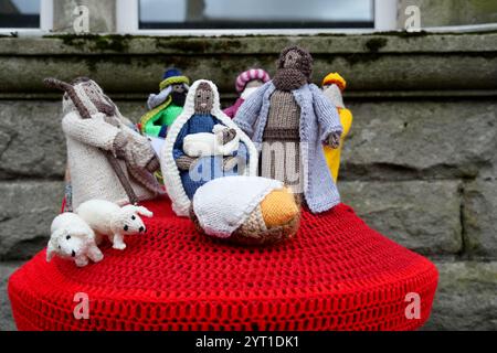 Eine bunte gestrickte Krippe auf einem Briefkasten. Stockfoto