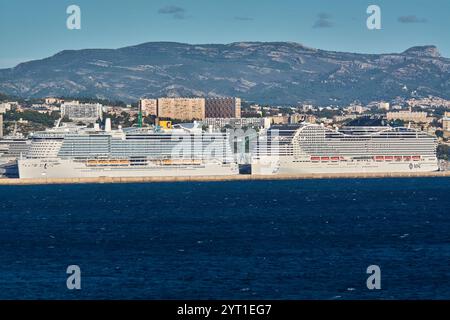 Marseille, Frankreich - 4. Dezember 2024: Zwei große Kreuzfahrtschiffe, Costa Smeralda und ein MSC-Linienschiff, legen im Hafen von Marseille an, mit den Gebäuden der Stadt und Stockfoto