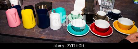 Bunte Tassen und Tassen für Kaffee und Tee an der Bar. Stockfoto