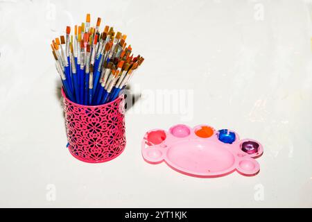 Neue Aquarellfarben mit Pinsel und weißem Blatt Papier. Weißer Hintergrund, Flat Lay, Leerzeichen für Text. Stockfoto