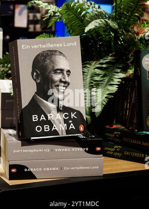 Deutschland, Passau - 5. Dezember 2024: Das Buch des 44. US-Präsidenten Barack Obama "das gelobte Land" im Regal eines Buchladens. Bücher des berühmten po Stockfoto